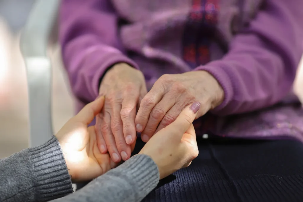 Young hands holding elderly hands